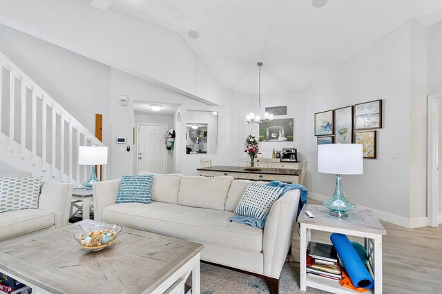 3773 NW 63rd Ct, Coconut Creek, FL 33073 - living room featuring a chandelier, light wood finished floors, baseboards, stairway, and lofted ceiling