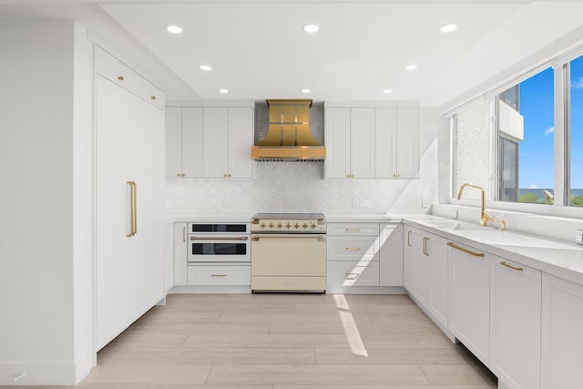 kitchen featuring custom range hood, a sink, recessed lighting, and white appliances