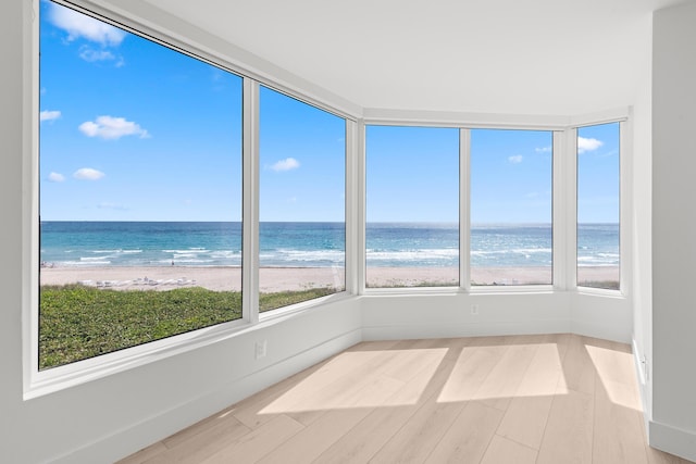 2575 S Ocean Blvd Unit 102S, Highland Beach, FL 33487 - unfurnished sunroom with view of water and beach, baseboards, and wood finished floors