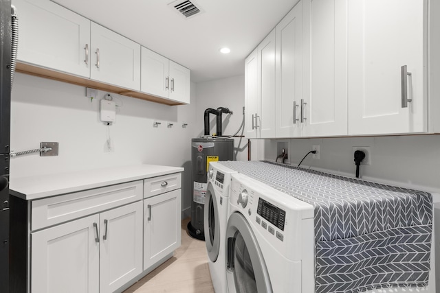 laundry area featuring visible vents, washing machine and dryer, recessed lighting, cabinet space, and water heater