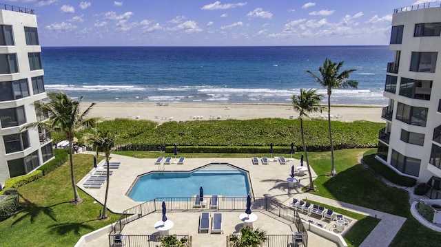 community pool with a beach view, a water view, and a patio