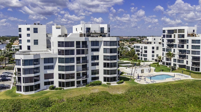 view of building exterior featuring a community pool and a city view