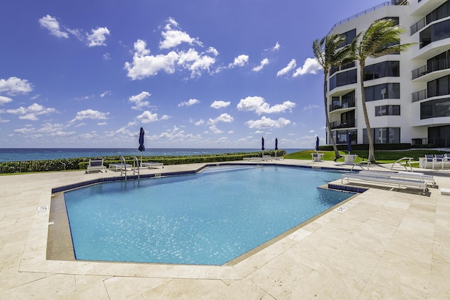community pool with a water view and a patio