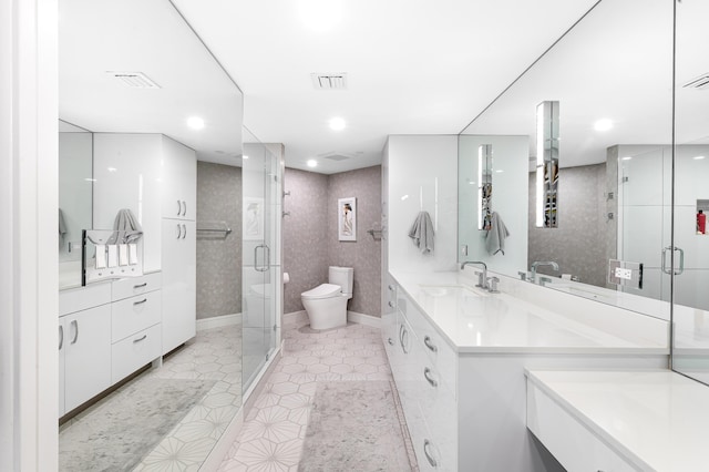 bathroom featuring a shower stall, toilet, vanity, tile patterned flooring, and baseboards