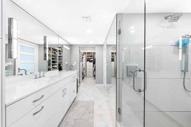 bathroom with a spacious closet, a stall shower, vanity, tile patterned flooring, and recessed lighting