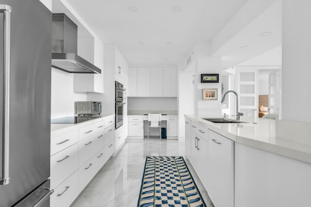kitchen with stainless steel appliances, wall chimney exhaust hood, a sink, modern cabinets, and light marble finish floors