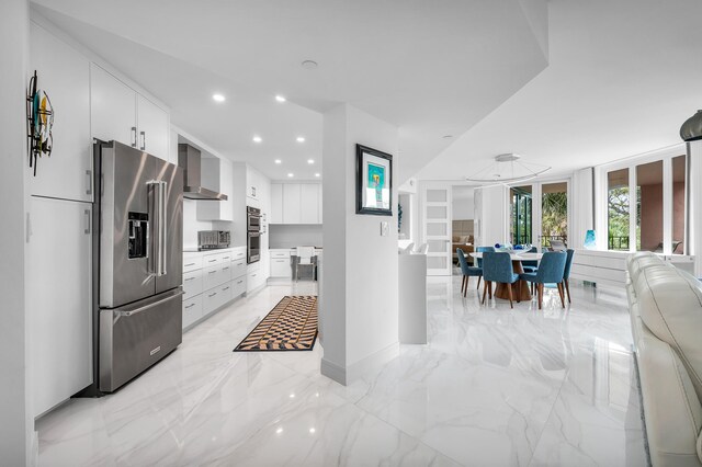 kitchen featuring stainless steel appliances, wall chimney exhaust hood, modern cabinets, open floor plan, and recessed lighting