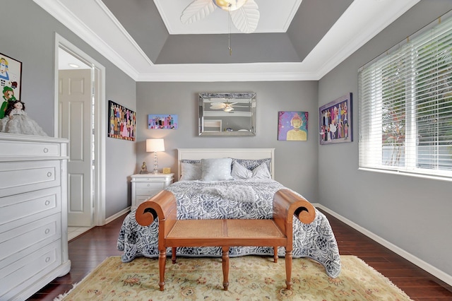 bedroom featuring a raised ceiling, crown molding, wood finished floors, and baseboards