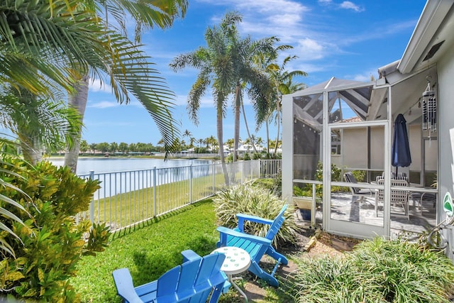 view of yard with a water view, a patio area, a fenced backyard, and a lanai