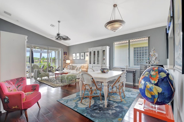 dining room featuring crown molding, a ceiling fan, visible vents, vaulted ceiling, and wood finished floors