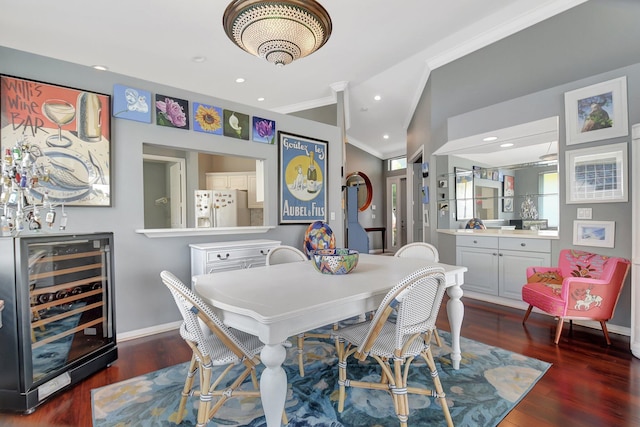 dining area with baseboards, vaulted ceiling, crown molding, wine cooler, and wood finished floors