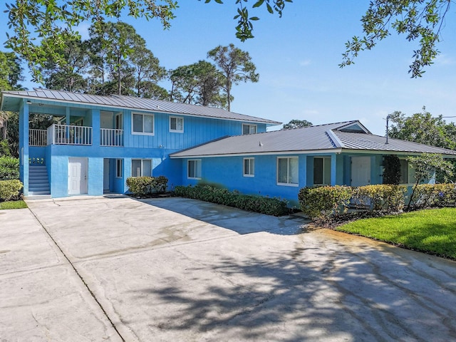 6881 Church St, Jupiter, FL 33458 - view of front of house featuring metal roof, a standing seam roof, and concrete driveway