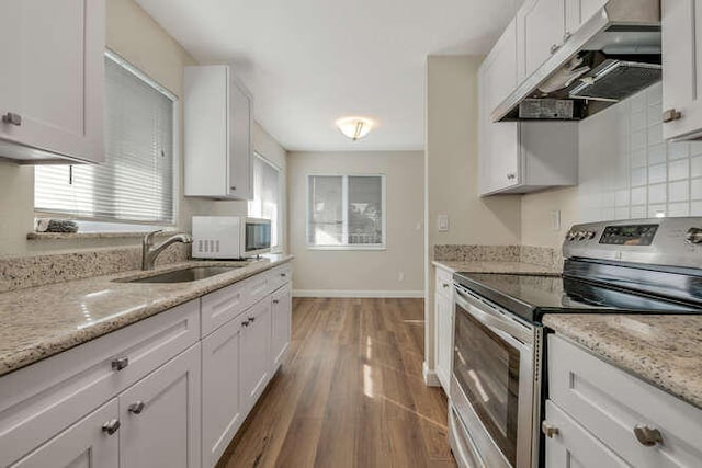 6881 Church St, Jupiter, FL 33458 - kitchen with a sink, stainless steel range with electric stovetop, white cabinets, white microwave, and extractor fan
