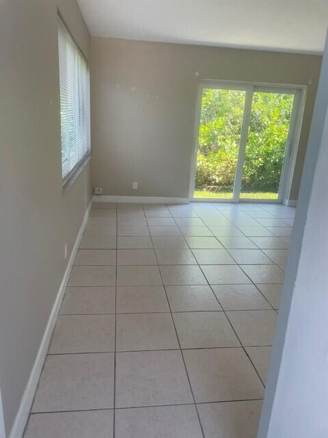 6881 Church St, Jupiter, FL 33458 - spare room with light tile patterned flooring and baseboards