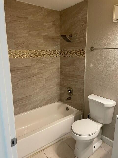 6881 Church St, Jupiter, FL 33458 - full bathroom with tile patterned flooring, shower / bathing tub combination, toilet, a textured wall, and baseboards