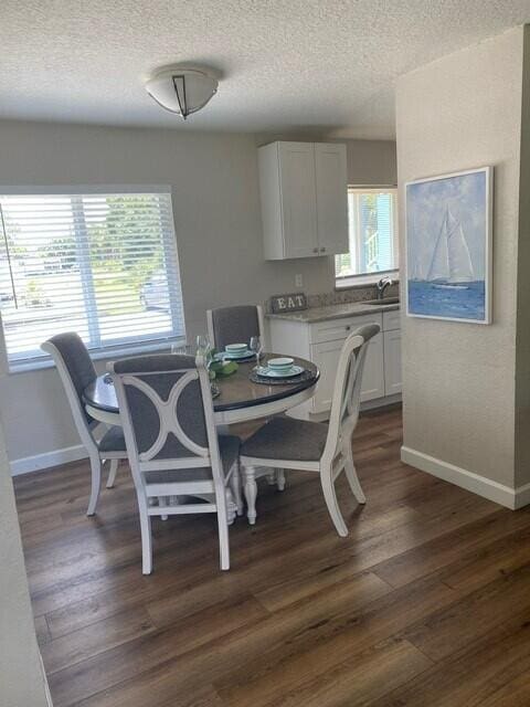 6881 Church St, Jupiter, FL 33458 - dining area featuring baseboards, a textured ceiling, and dark wood-style flooring