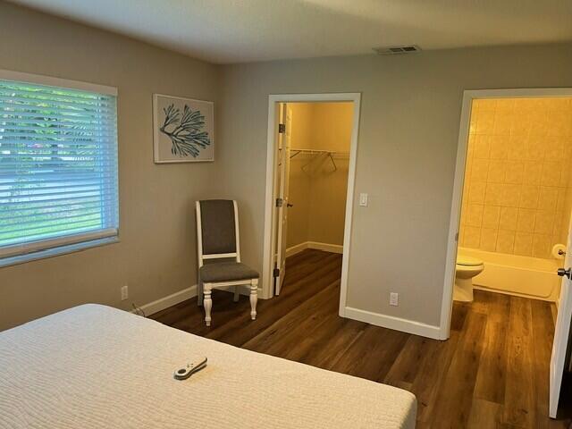 6881 Church St, Jupiter, FL 33458 - bedroom featuring baseboards, dark wood-style flooring, and visible vents