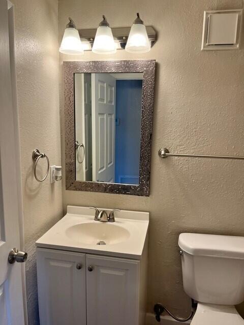6881 Church St, Jupiter, FL 33458 - half bath featuring a textured wall, toilet, and vanity