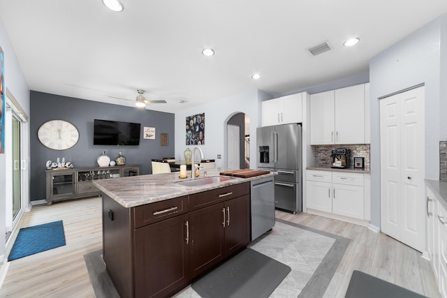 kitchen with arched walkways, a ceiling fan, visible vents, appliances with stainless steel finishes, and a sink