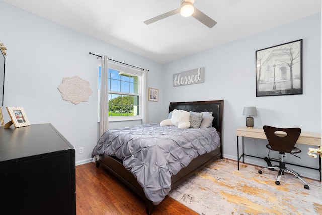 bedroom featuring baseboards, a ceiling fan, and wood finished floors