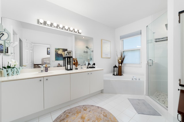 full bath featuring a bath, tile patterned flooring, a sink, a stall shower, and double vanity