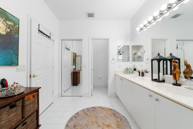 bathroom with double vanity, a sink, tile patterned flooring, and visible vents