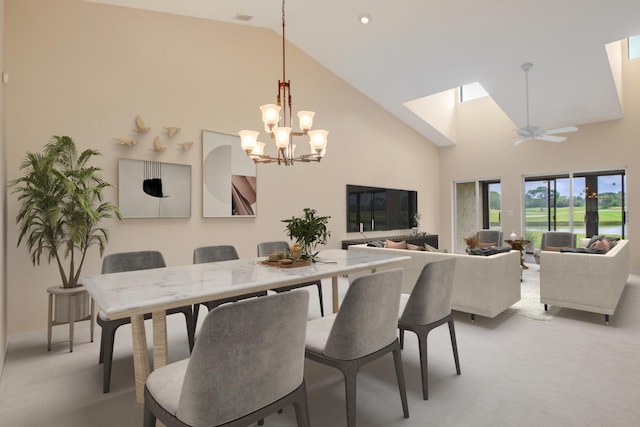 dining space featuring high vaulted ceiling, a skylight, ceiling fan with notable chandelier, and light carpet