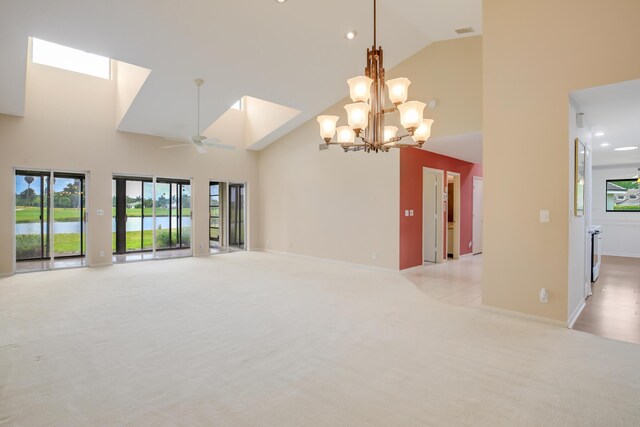 spare room featuring high vaulted ceiling, ceiling fan with notable chandelier, and light colored carpet