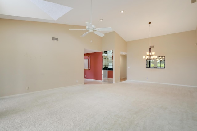 empty room with light colored carpet, high vaulted ceiling, visible vents, and baseboards