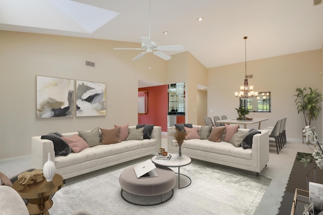 living area with visible vents, high vaulted ceiling, baseboards, ceiling fan with notable chandelier, and light carpet