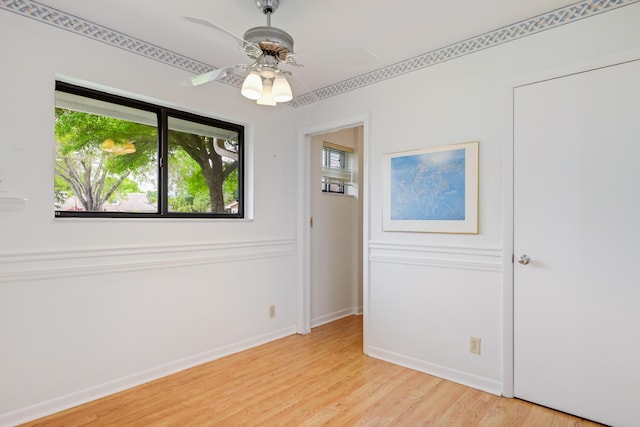 spare room with light wood-style floors, baseboards, and ceiling fan