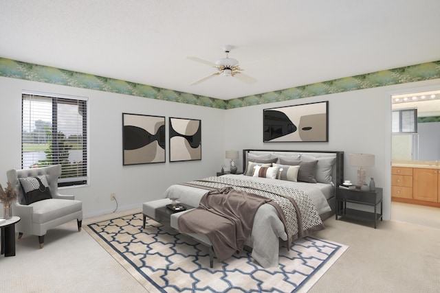 bedroom featuring baseboards, light colored carpet, multiple windows, and ensuite bathroom