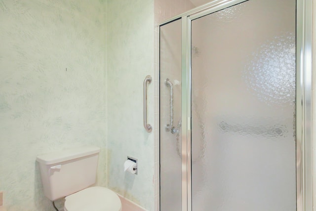 bathroom featuring a stall shower and toilet