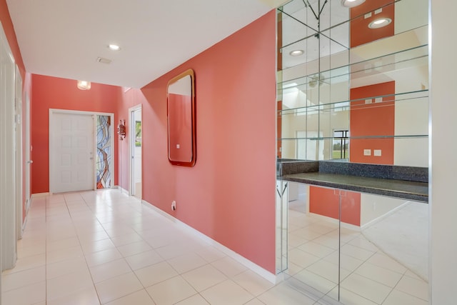 corridor with baseboards, recessed lighting, tile patterned floors, and a healthy amount of sunlight