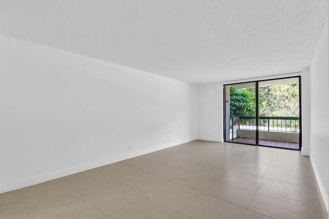 277 N Ocean Blvd Unit 1010, Boca Raton, FL 33432 - tiled empty room with expansive windows, a textured ceiling, and baseboards