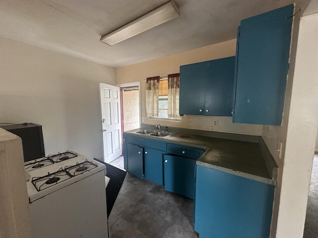 kitchen featuring a sink, blue cabinetry, and white gas range oven