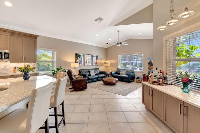 8353 Grand Messina Cir, Boynton Beach, FL 33472 - living area featuring a ceiling fan, crown molding, light tile patterned flooring, visible vents, and lofted ceiling