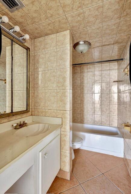full bathroom featuring tile patterned floors, toilet, vanity, and washtub / shower combination