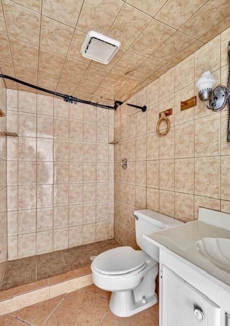 full bath featuring a stall shower, vanity, toilet, and tile patterned flooring