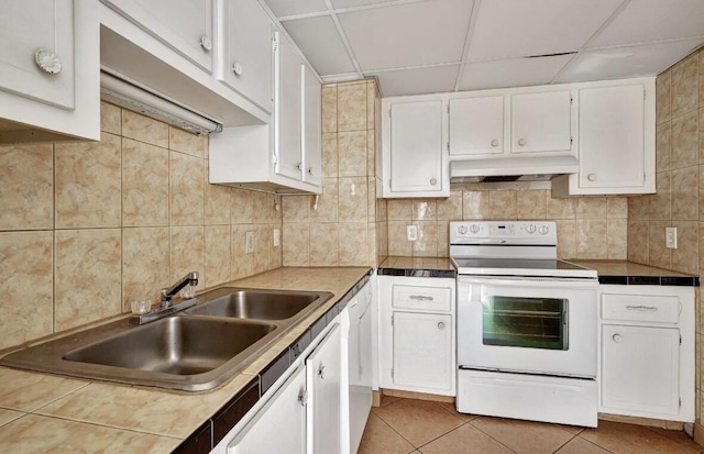kitchen with white appliances, a sink, under cabinet range hood, white cabinets, and backsplash