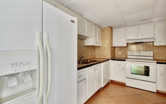 kitchen with white appliances, under cabinet range hood, a sink, light tile patterned floors, and backsplash