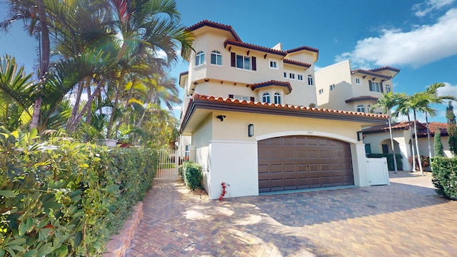 1942 NE 6th St, Deerfield Beach, FL 33441 - mediterranean / spanish house with stucco siding, a tile roof, fence, and decorative driveway