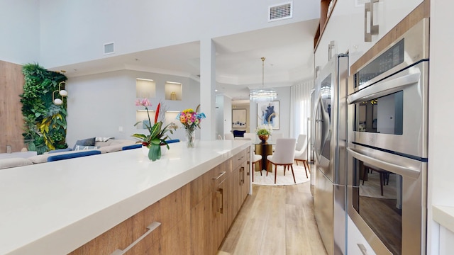 1942 NE 6th St, Deerfield Beach, FL 33441 - kitchen featuring visible vents, light wood finished floors, modern cabinets, appliances with stainless steel finishes, and open floor plan