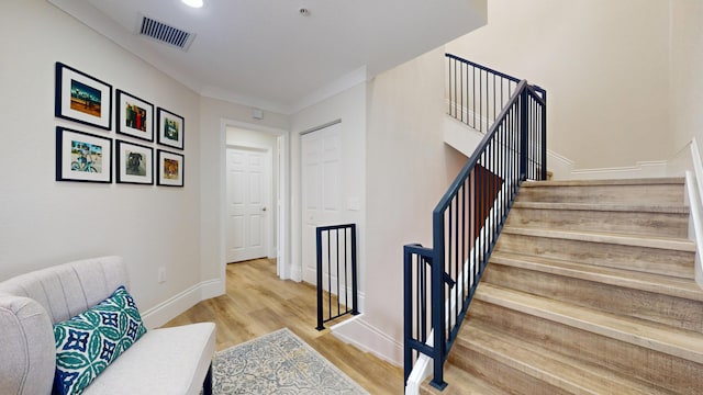 1942 NE 6th St, Deerfield Beach, FL 33441 - staircase with wood finished floors, crown molding, baseboards, and visible vents