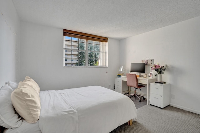 bedroom featuring light carpet, baseboards, and a textured ceiling