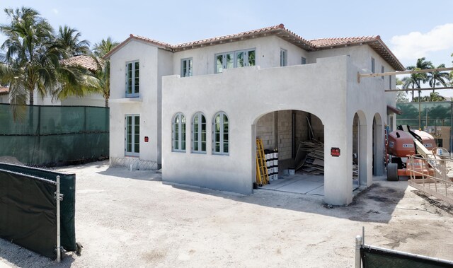 back of house with a tile roof, a patio area, fence, a balcony, and stucco siding