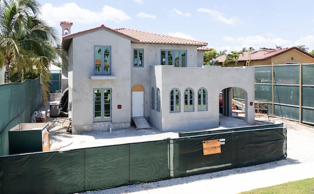 view of front of home with a fenced backyard, stucco siding, a chimney, and a tile roof