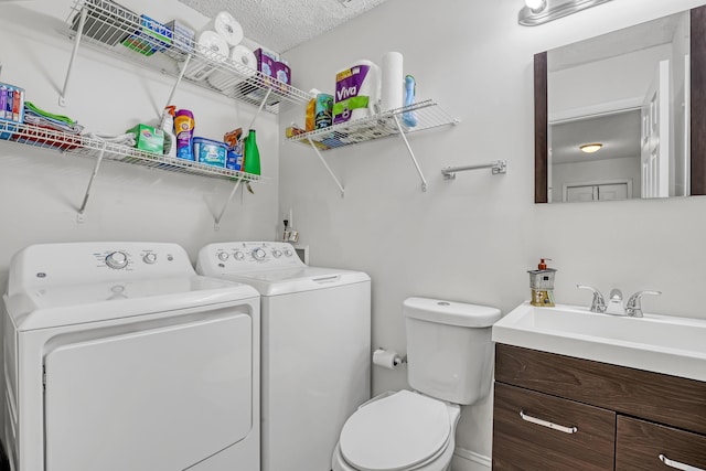 bathroom featuring vanity, a textured ceiling, toilet, and washer and dryer