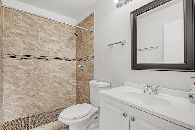 bathroom with toilet, vanity, and tiled shower