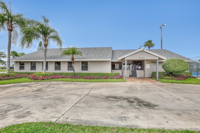 view of front of property featuring an attached carport, concrete driveway, and stucco siding